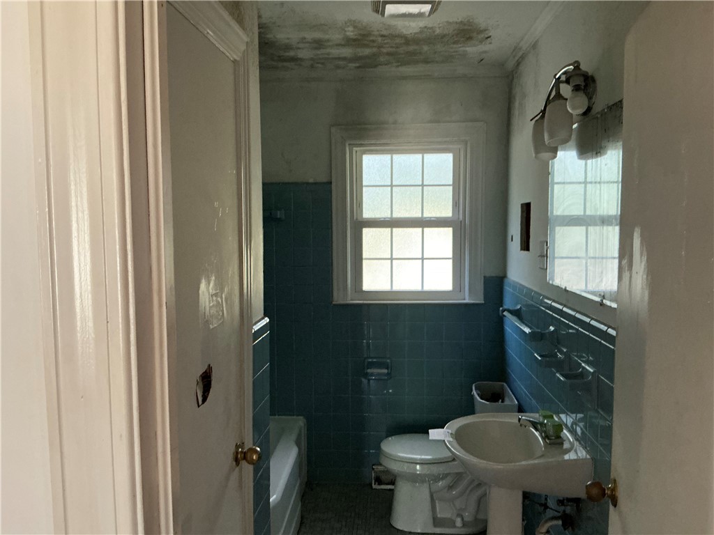 609 West Geer Street Honea Path, SC 29654 - Photo 8 of 12 A classic tiled bathroom awaits renovation to restore its original charm.