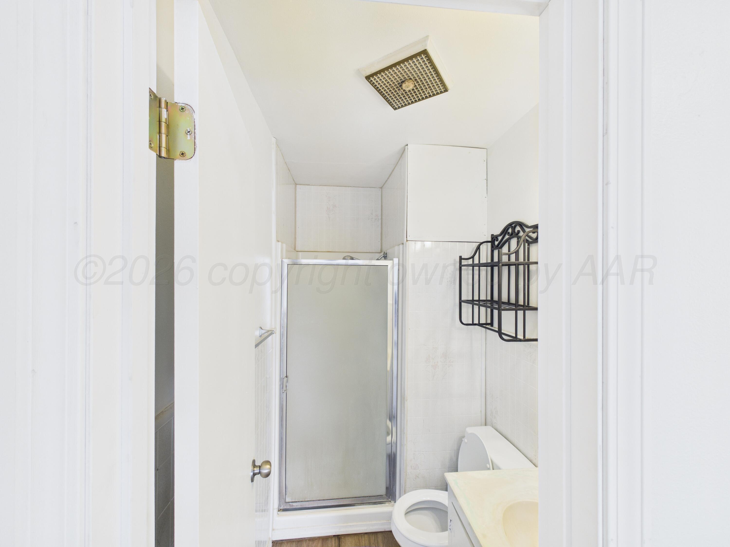 813 Northeast 3rd Street Dumas, TX 79029 - Photo 20 of 22 a bathroom with a window and a shower