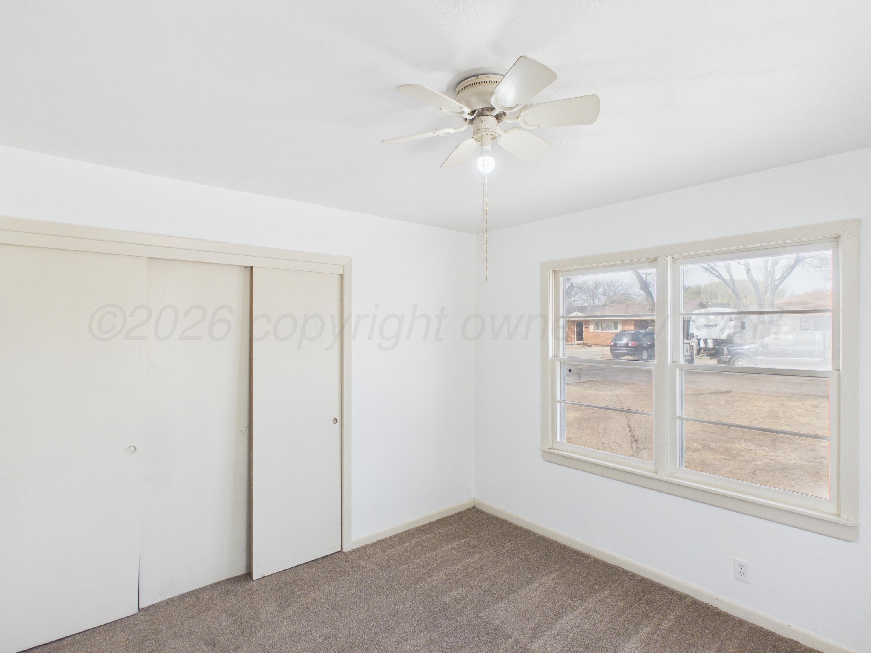813 Northeast 3rd Street Dumas, TX 79029 - Photo 5 of 22 a view of an empty room with a window
