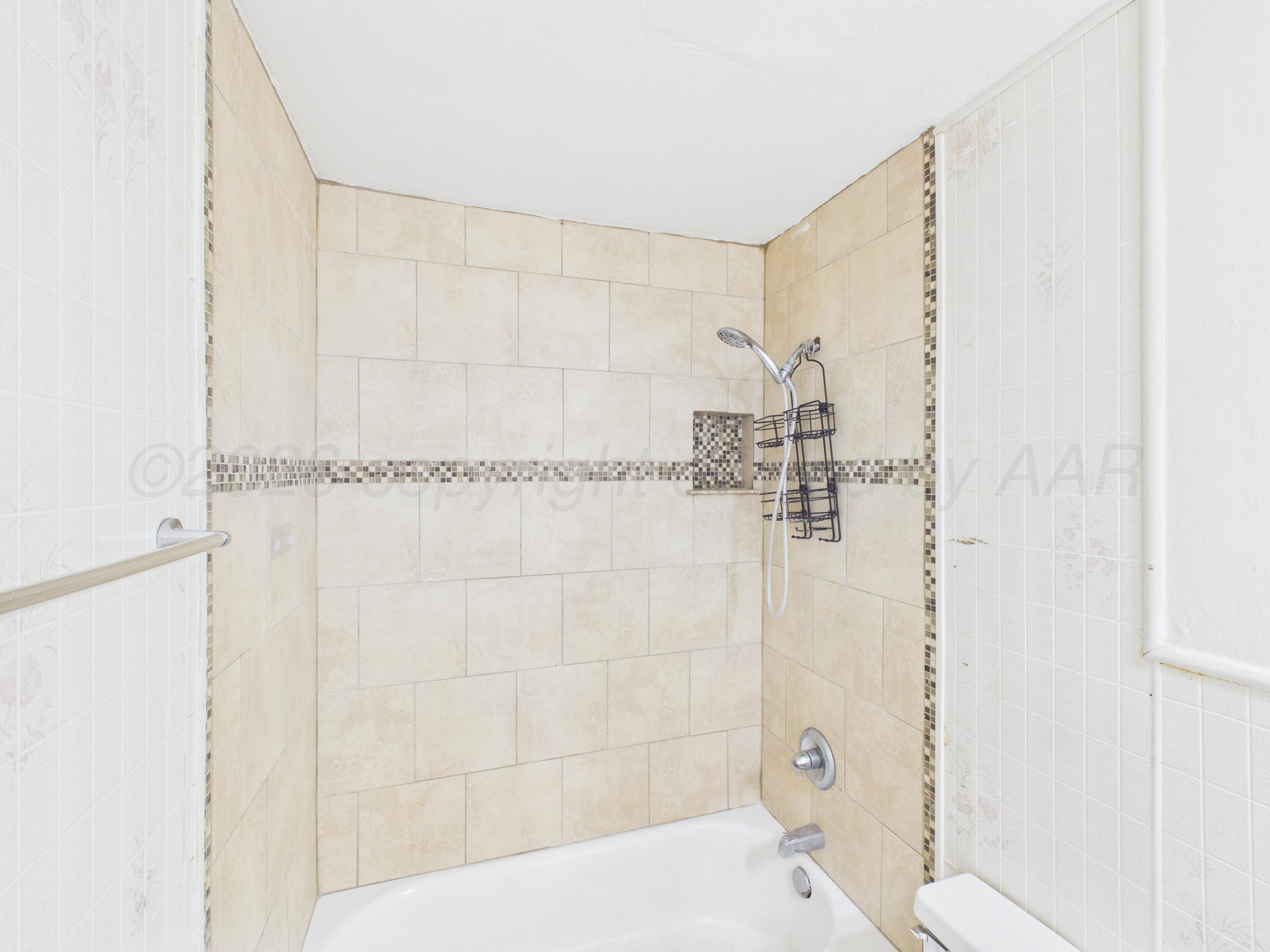 813 Northeast 3rd Street Dumas, TX 79029 - Photo 10 of 22 a bathroom with a shower and a sink