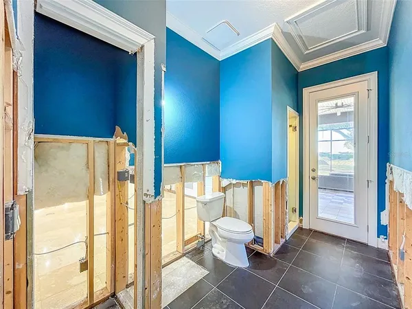 a view of a bedroom with wooden floor and a ceiling fan