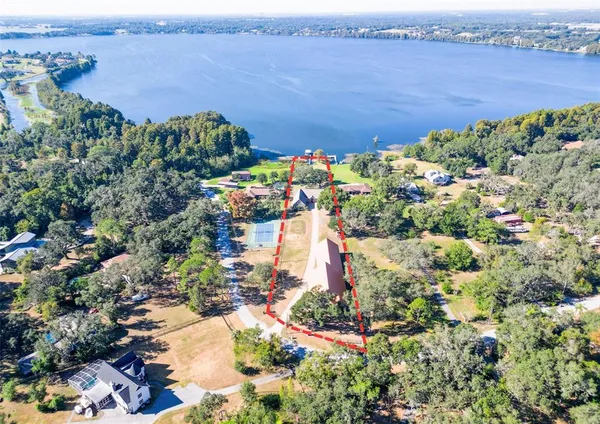 a kitchen with stainless steel appliances granite countertop a refrigerator a stove and a sink with wooden floor