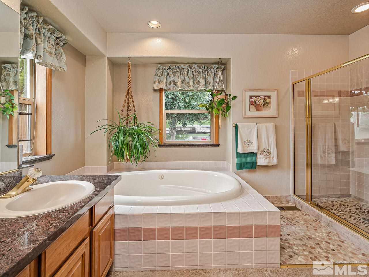 35 Calla Lily Court Reno, NV 89511 - Photo 18 of 39 a spacious bathroom with a granite countertop tub sink and mirror