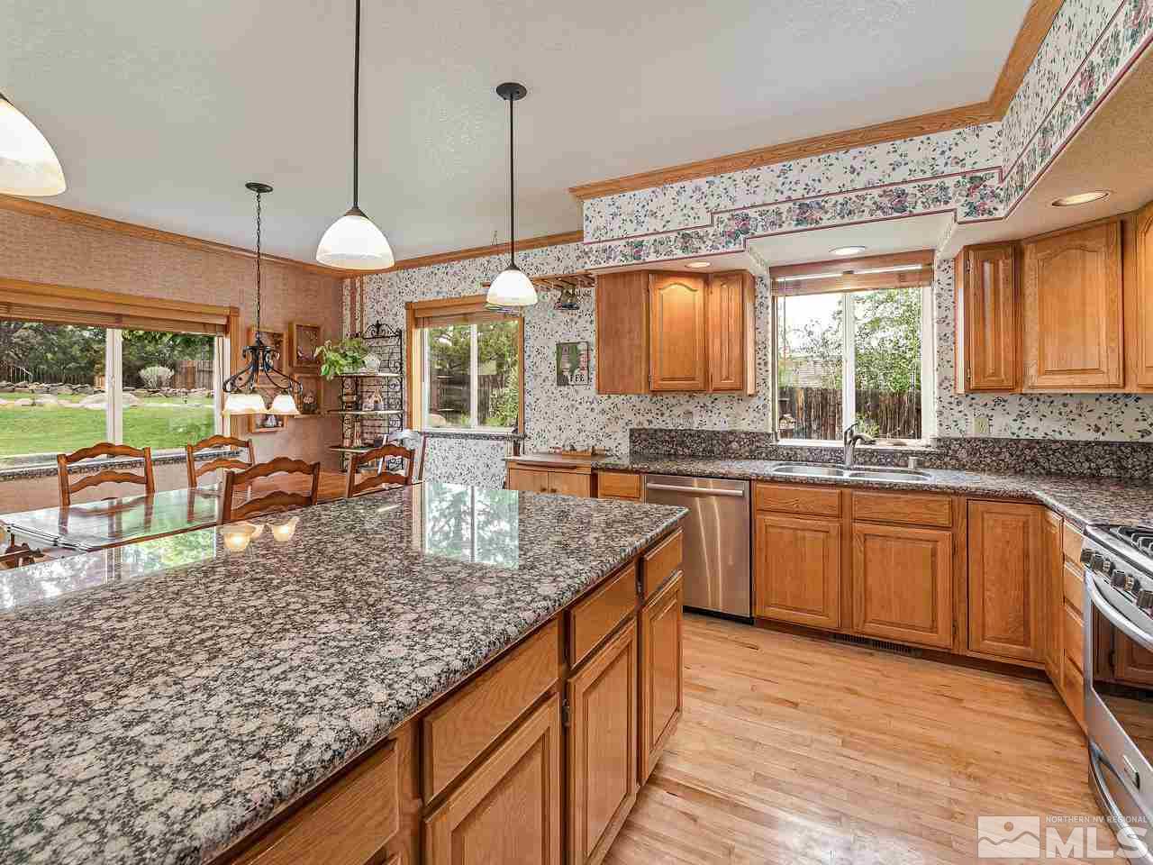 35 Calla Lily Court Reno, NV 89511 - Photo 6 of 39 a kitchen with granite countertop a stove a sink and a wooden cabinets
