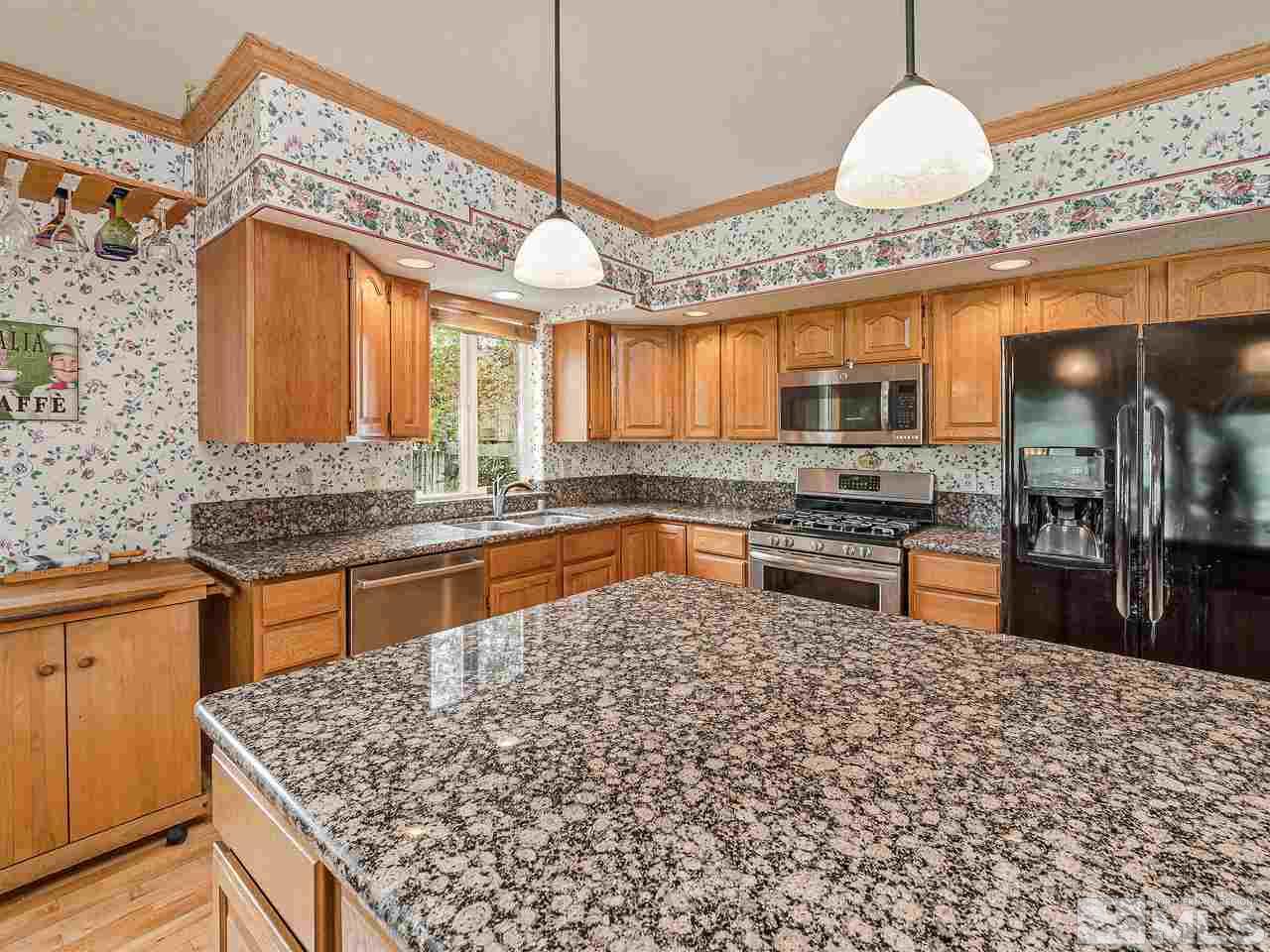 35 Calla Lily Court Reno, NV 89511 - Photo 7 of 39 a kitchen with stainless steel appliances granite countertop a sink a stove top oven a counter space and cabinets