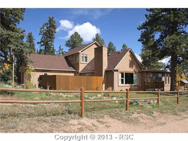 1122 NORTH Rd Divide Divide, CO 80814 - Photo 4 of 25 Split rail fencing showcases the front of the home and you won't believe the size of the ponderosa in the front