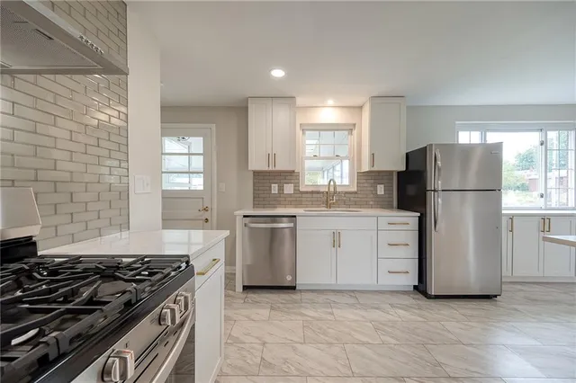 a kitchen with a stove a refrigerator and a sink