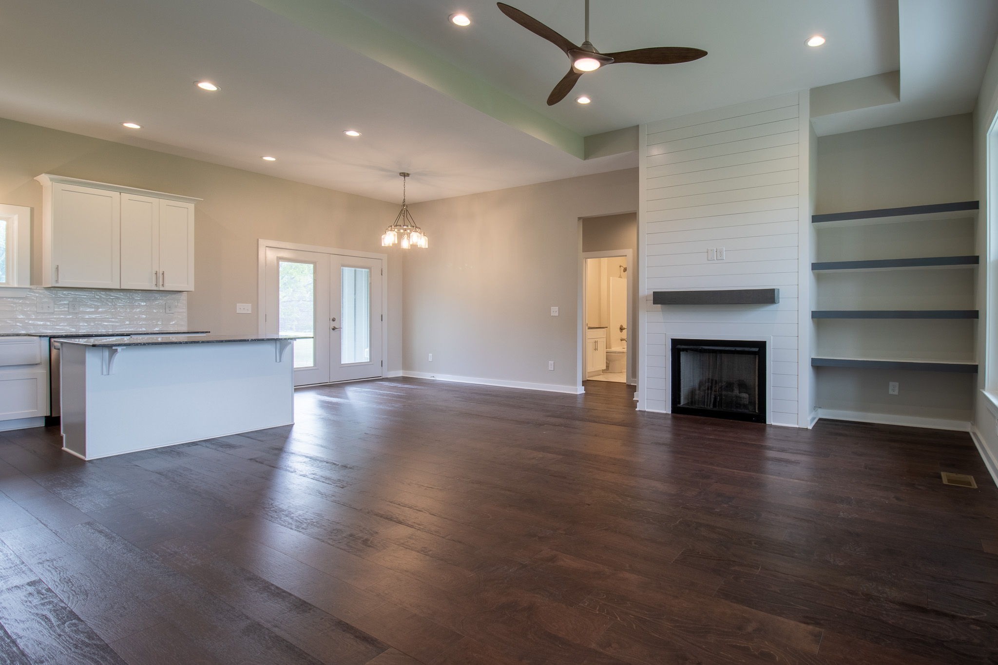 264 Dink Rut Road Portland, TN 37148 - Photo 16 of 56 an empty room with wooden floor fireplace and windows