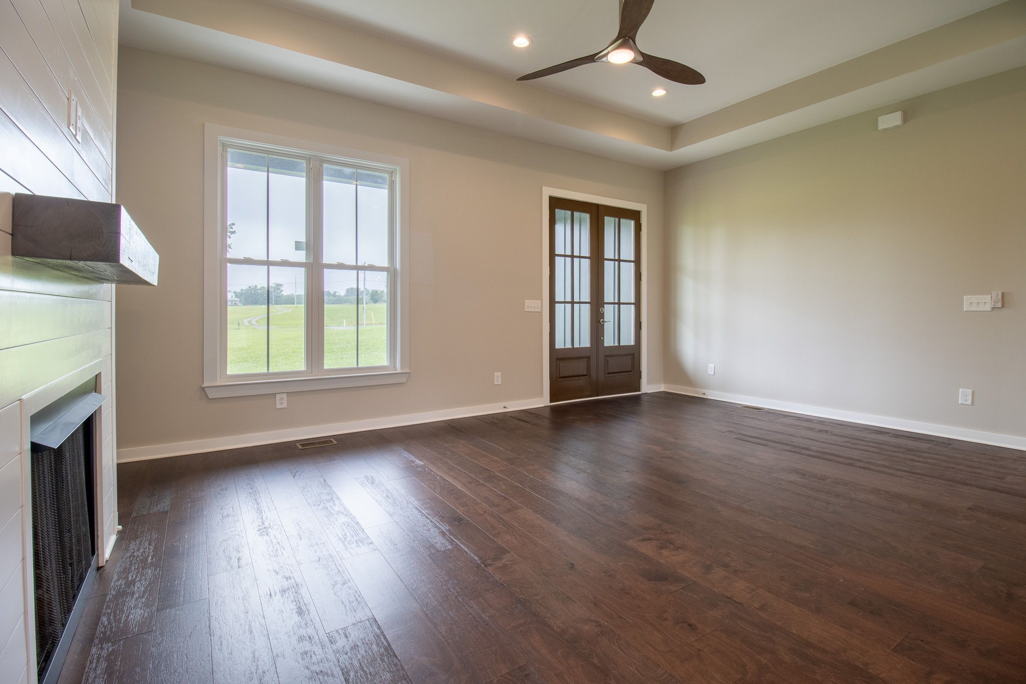 264 Dink Rut Road Portland, TN 37148 - Photo 17 of 56 an empty room with wooden floor fireplace and windows