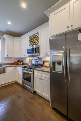 a kitchen with a refrigerator stove and white cabinets