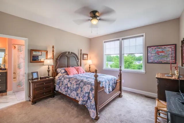 a bedroom with a bed a chandelier and a window