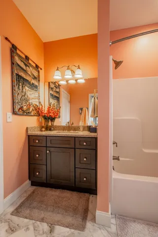 a bathroom with a tub sink and mirror