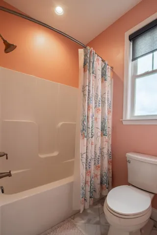 a white toilet sitting next to a bath tub