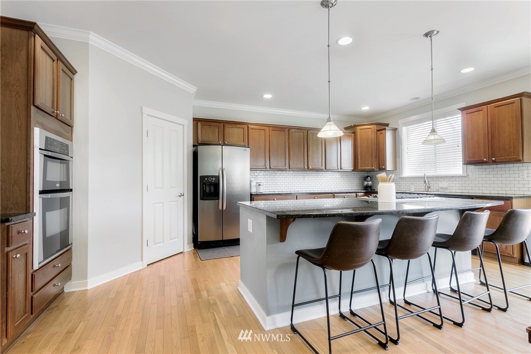 3922 216th Place Southeast Bothell, WA 98021 - Photo 6 of 33 a kitchen with stainless steel appliances granite countertop a sink a stove a refrigerator and island with wooden floor