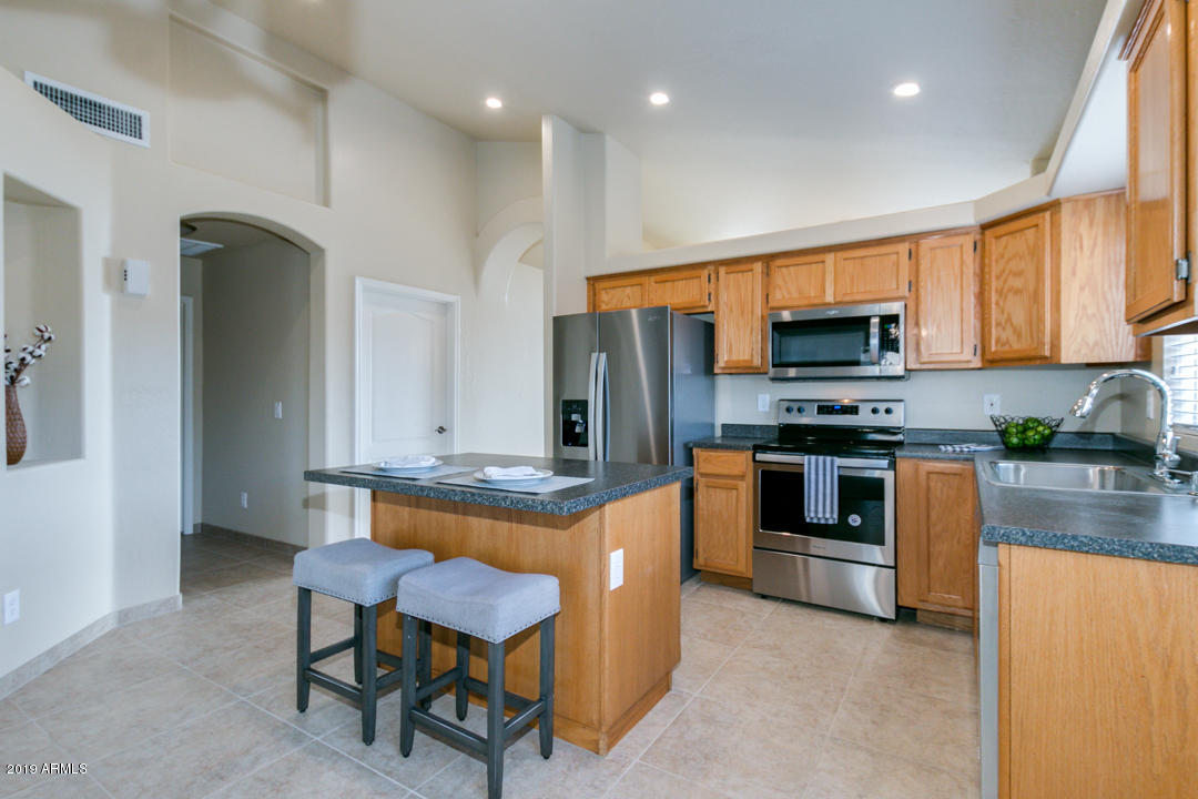 7292 South Roberts Road Tempe, AZ 85283 - Photo 16 of 38 a kitchen with stainless steel appliances a stove a sink a microwave a refrigerator and cabinets