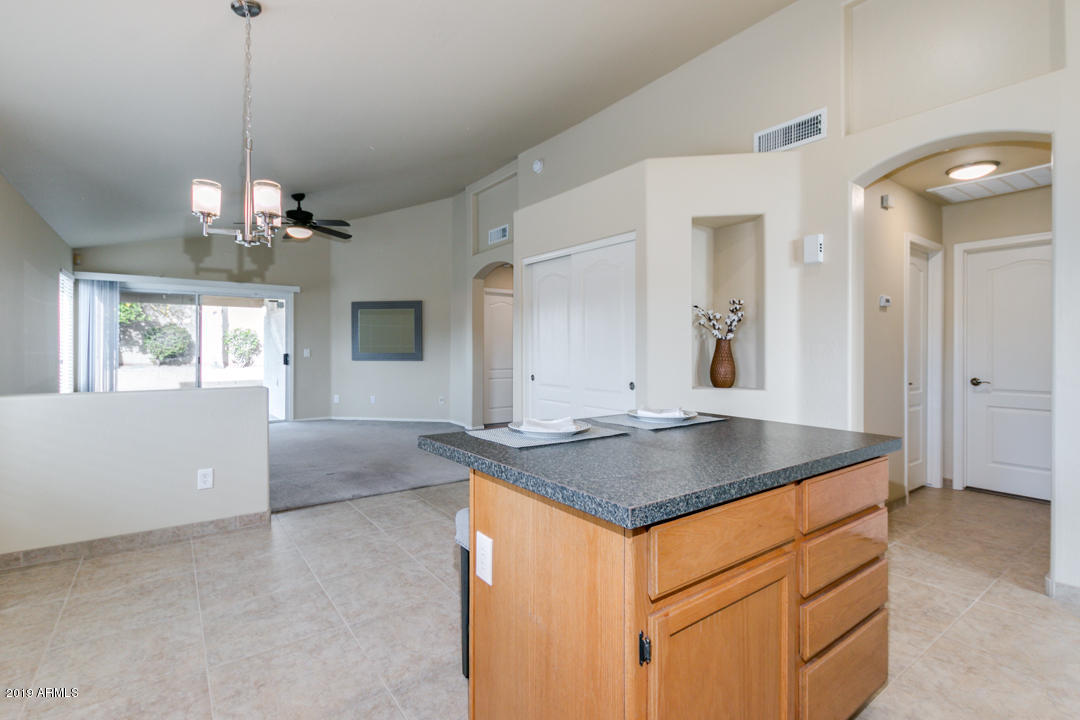 7292 South Roberts Road Tempe, AZ 85283 - Photo 17 of 38 a kitchen with stainless steel appliances granite countertop a sink a center island a stove and a window