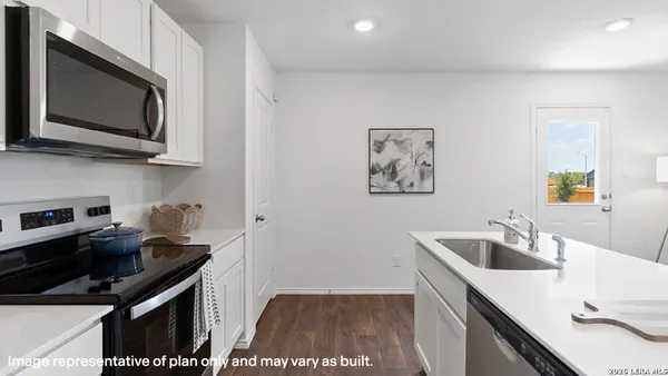 a kitchen with stainless steel appliances a sink a stove a microwave a counter top space and cabinets