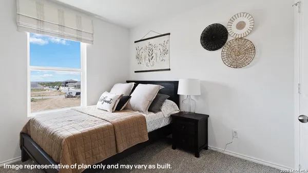 a bedroom with a bed and painting on the wall