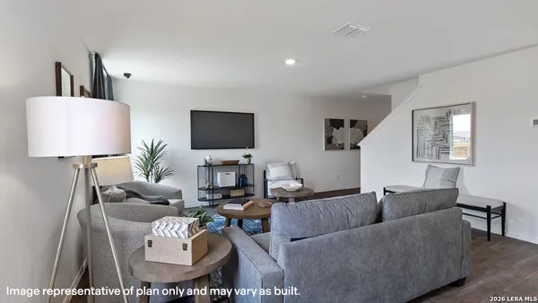 a living room with furniture a lamp and a flat screen tv