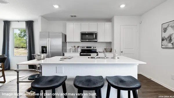 a kitchen with stainless steel appliances a dining table and chairs