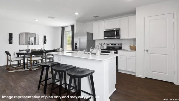 a kitchen with stainless steel appliances kitchen island granite countertop a stove a sink a dining table and chairs