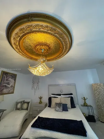 a bedroom with bed and a chandelier