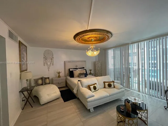 a living room with a bed and a chandelier