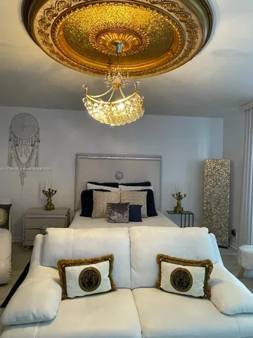 a bedroom with a bed and a chandelier