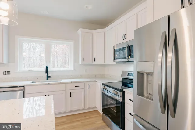 a kitchen with stainless steel appliances white cabinets and a refrigerator