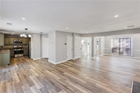 a view of an empty room with wooden floor and windows