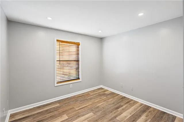 an empty room with wooden floor and closet area
