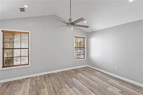 a view of a room with a ceiling fan window and wooden floor