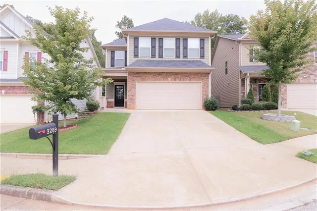 a front view of a house with a garden and trees