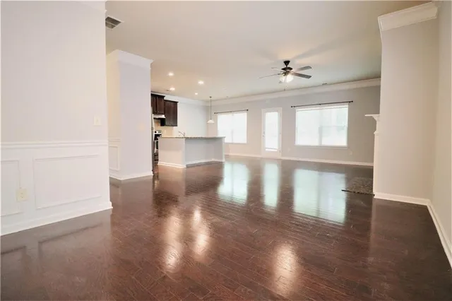 a view of empty room with wooden floor and windows