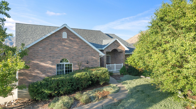 555 East 1700 N Street Mapleton, UT 84664 - Photo 12 of 49 Brick exterior with a gabled roofline, arched window, and covered entryway with white railings