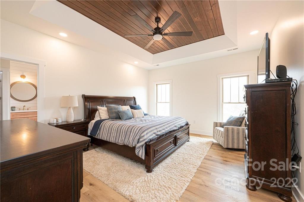 1289 Hopewell Church Road Hiddenite, NC 28636 - Photo 26 of 48 a spacious bedroom with a bed and a chandelier