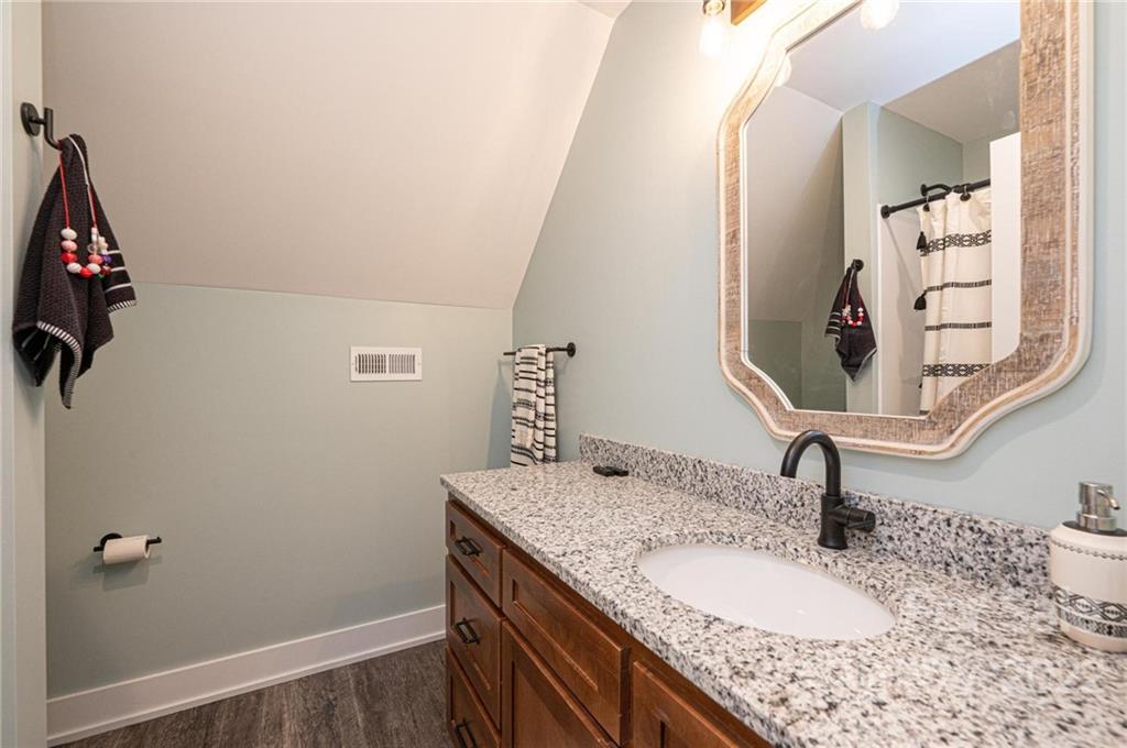 1289 Hopewell Church Road Hiddenite, NC 28636 - Photo 39 of 48 a bathroom with a granite countertop sink a mirror and vanity
