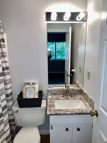 a bathroom with a granite countertop sink and a mirror