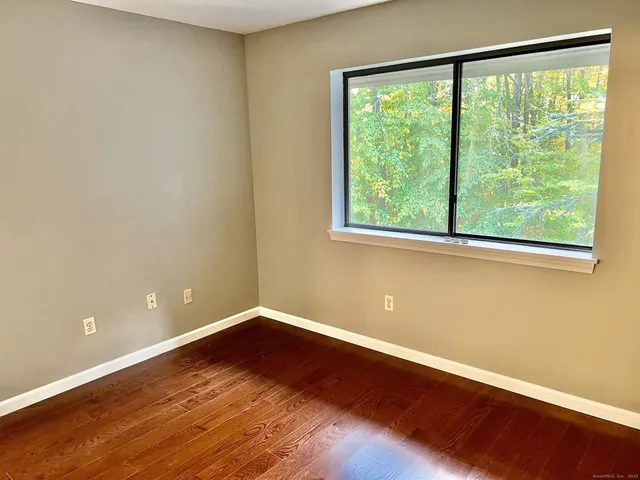 a view of a room with wooden floor and a window