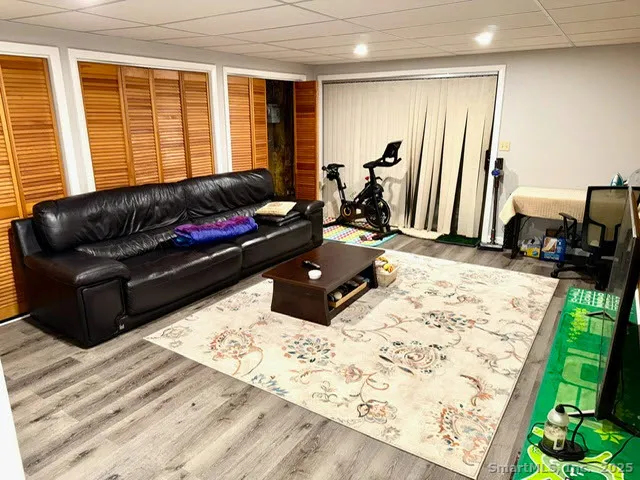 a living room with a bed furniture and a flat screen tv