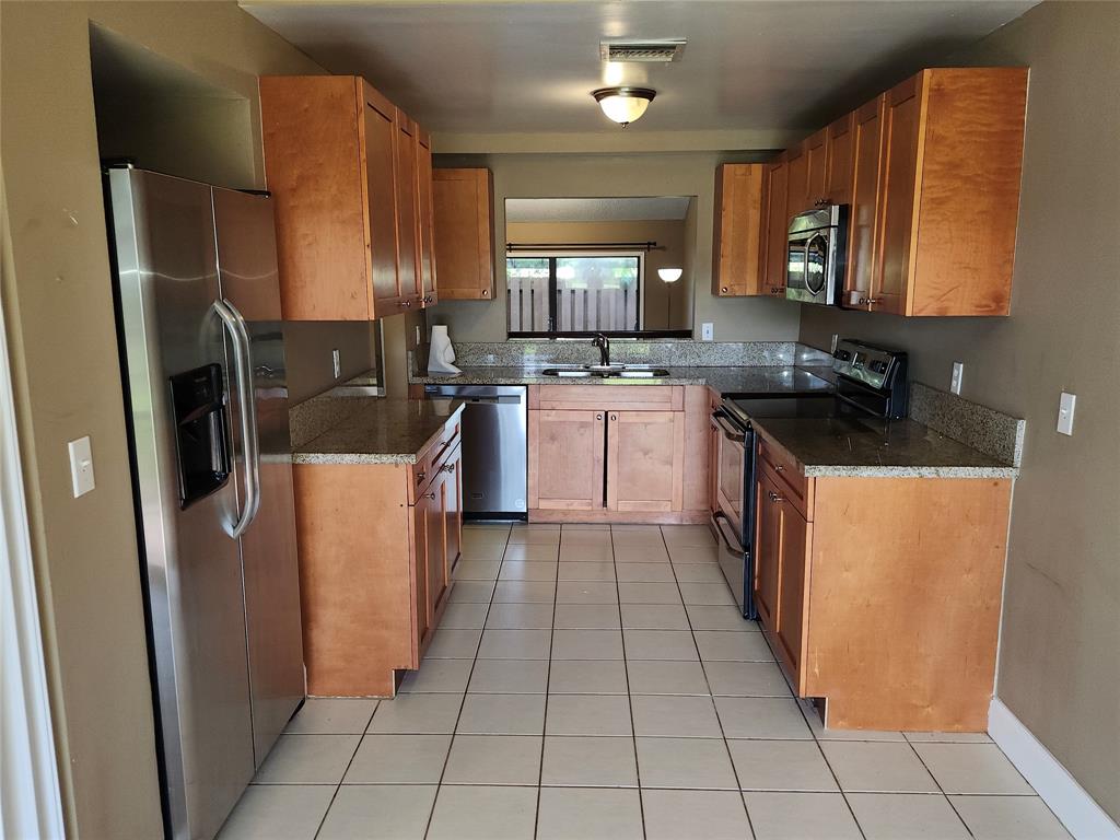 4192 Southwest 87th Terrace Davie, FL 33328 - Photo 13 of 35 a kitchen with stainless steel appliances a refrigerator sink and cabinets