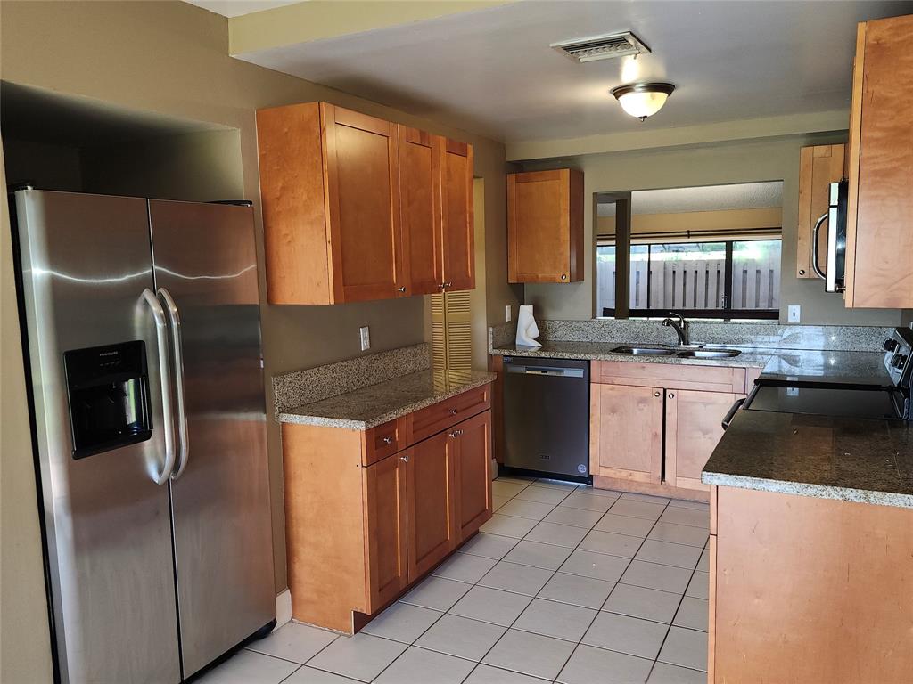 4192 Southwest 87th Terrace Davie, FL 33328 - Photo 14 of 35 a kitchen with stainless steel appliances granite countertop a sink stove and refrigerator