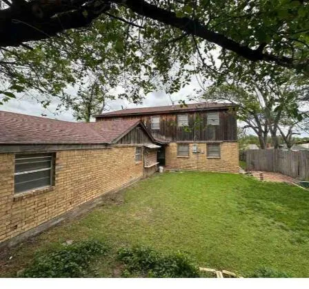 a view of a backyard with a garden and tree