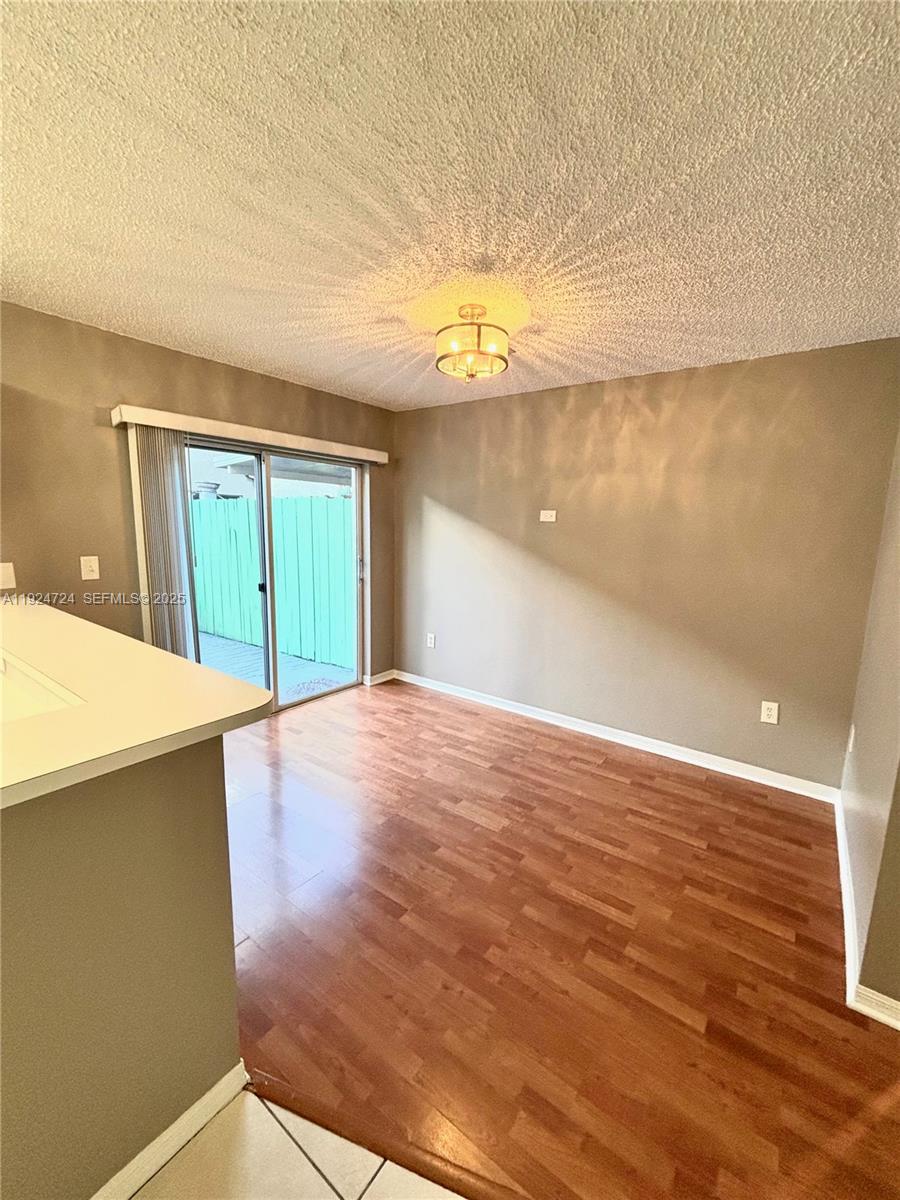 6965 Northwest 173rd Drive, Unit 1904 Hialeah, FL 33015 - Photo 5 of 14 a view of an empty room with wooden floor and a window