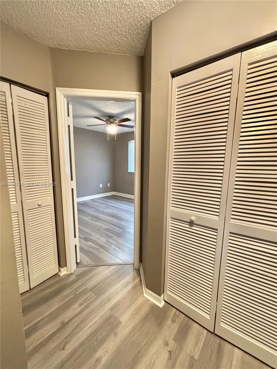 6965 Northwest 173rd Drive, Unit 1904 Hialeah, FL 33015 - Photo 8 of 14 an empty room with wooden floor and windows