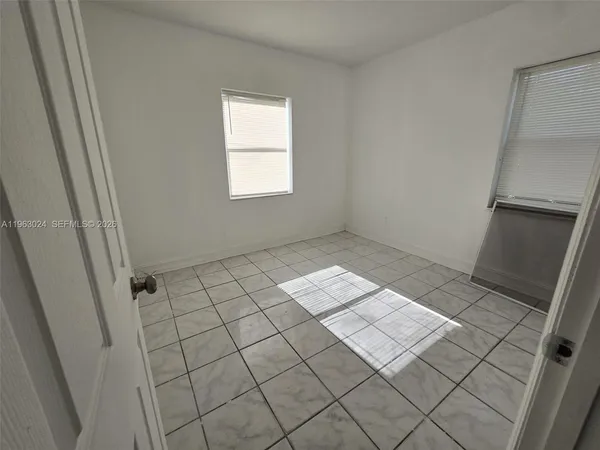 a view of an empty room and a bathroom