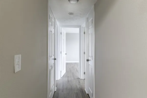 a view of a hallway with wooden floor