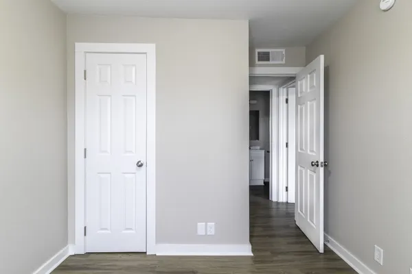 an empty room with wooden floor and closet