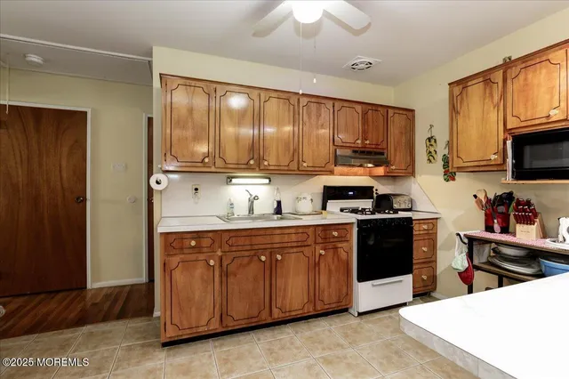 a kitchen with stainless steel appliances granite countertop a stove a sink dishwasher and a refrigerator