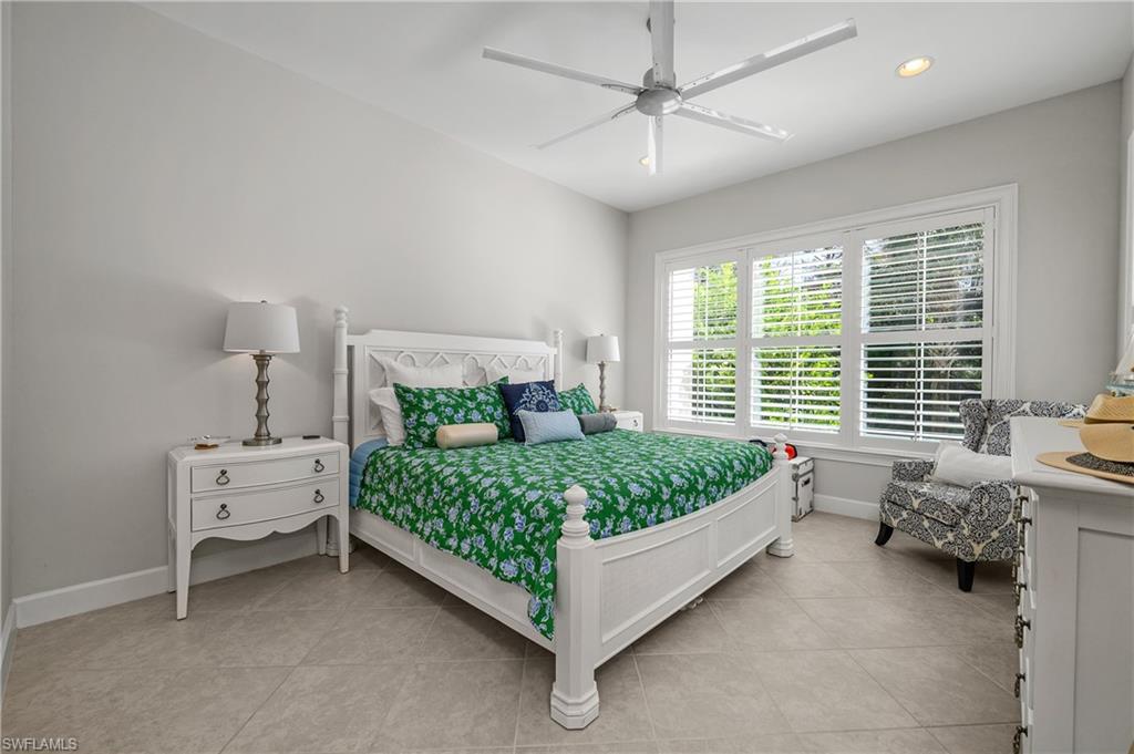 6552 Dominica Drive, Unit 101 Naples, FL 34113 - Photo 16 of 50 a bed sitting in a bedroom next to a window and a chandelier